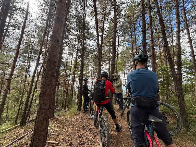 A group of mountain bikers during a backcountry expedition in the Ligurian Alps, specialized in multi-day MTB trips and wilderness exploration.