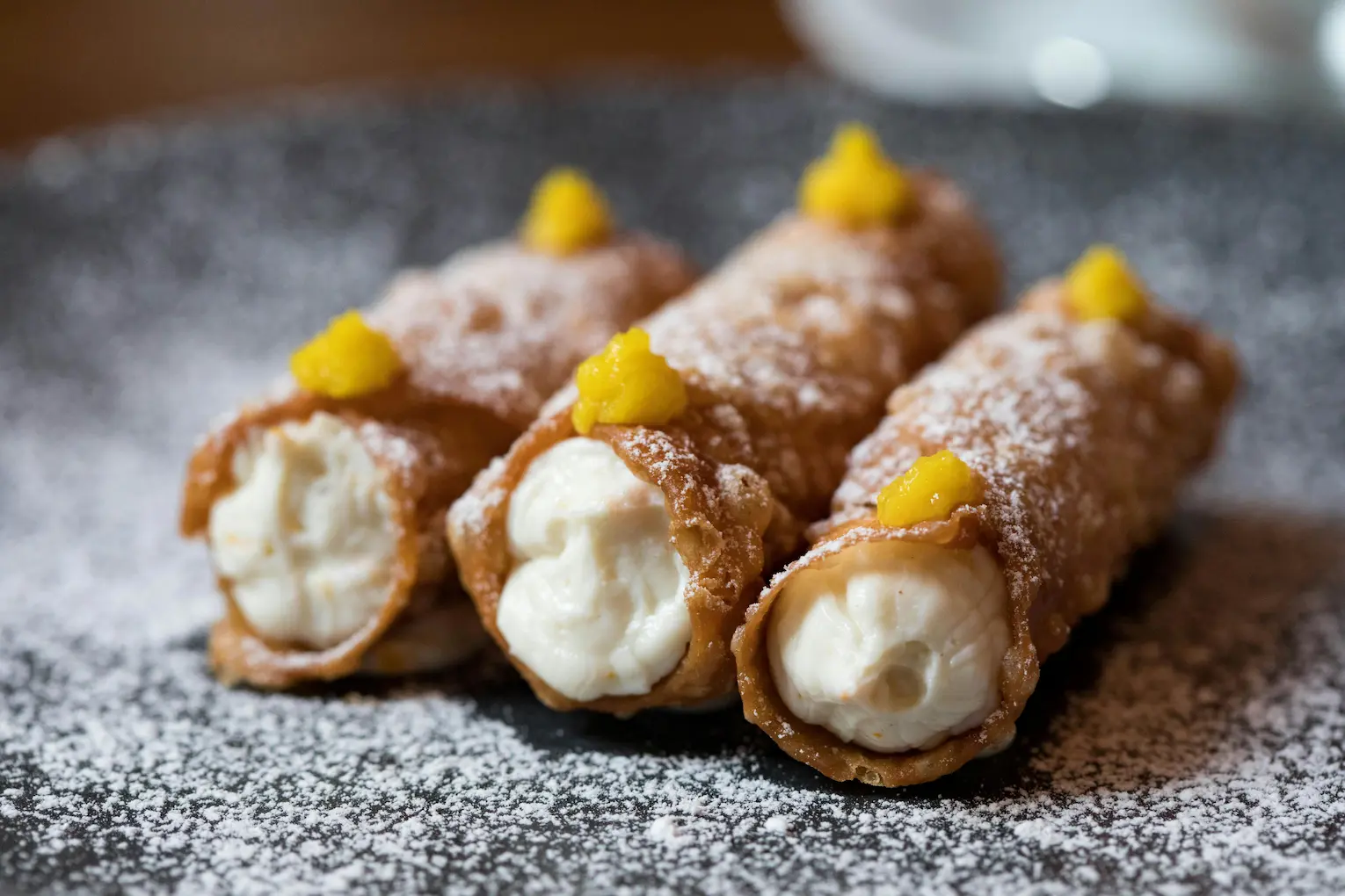 Traditional Sicilian cannoli dusted with powdered sugar, representing the authentic local flavors of the Riding into the Lava MTB tour.