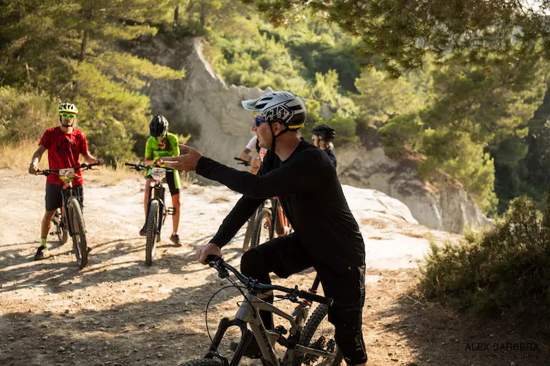 MTB guide Stefano explaining the trail features and safety instructions to a group of mountain bikers during a Trails Unlimited tour